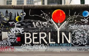 Mauerkunst. Der Berlin-Teil, der East-Side-Gallery, mit weißer Typografie auf schwarzem Grund und rotem Ballon.