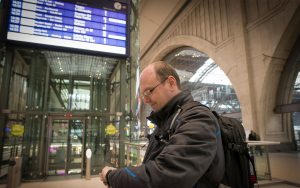 Railmen-Lokführer Jan Krehl steht in der Ankunftshalle des HBF Leipzig und prüft die Pünktlichkeit der MRB.