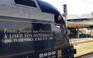 ÖBB Triebwagen mit Lokführer der durch das Fenster in die Kamera lächelt