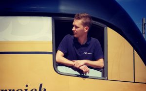 railmen Lokführer schaut aus dem Seitenfenster des Triebwagens