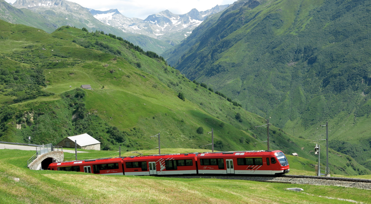 ©FOTO: ERIK LIEBETRUTH | RAILMEN-LOKFÜHRER | Auf die Minute pünktlich passiert die Zahnradbahn der Matterhorn‐Gotthardbahn einen Tunnel oberhalb von Andermatt auf dem Weg über den Oberalbpass nach Disentis‐Mustér im Schweizer Kanton Uri.